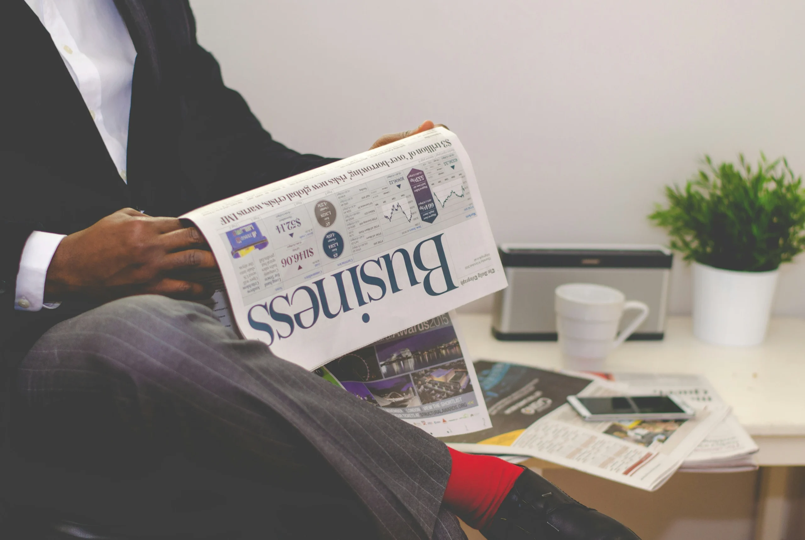 man reading a newspaper with a business headline